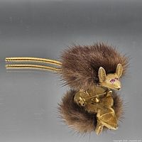 Front view showing fur body, gold-tone head, tail and pink rhinestone eyes