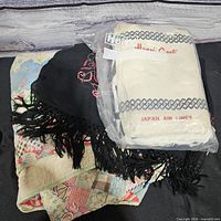 All three items stacked: quilt base, shawl draped, JAL bag on top