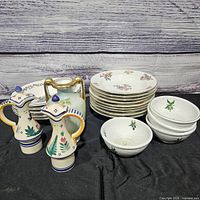 Group shot showing stacks of plates, bowls, two pitchers and small vase