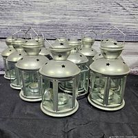 Group view of all ten silver metal and glass lanterns