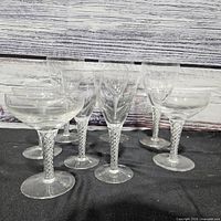 Eight clear twisted-stem glasses grouped on table