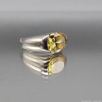 Ring front view showing yellow glass stone and bezel setting