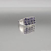 Front view of sterling silver ring showing rectangular cluster of nine blue-violet stones