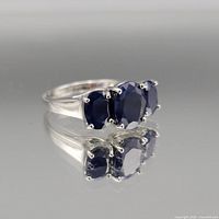 Front view showing three oval blue sapphires and prong setting