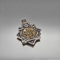 Front view showing star shape, gold-tone medallion, and bail detail