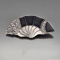 Front view of fan-shaped silver brooch with black panels