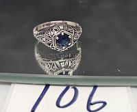 Front view of sterling silver filigree ring with blue sapphire and clear stones