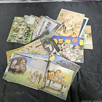 Overhead view of mixed illustrated postcards spread on black backdrop