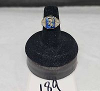 Full view of ring on display cone showing blue intaglio stone and silvertone band