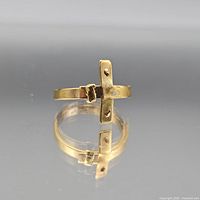 Ring on reflective surface showing cross design