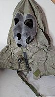 Front view of olive drab protective hood with mask interface openings and zipper