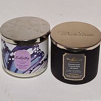 Front view of both candles showing labels and lids
