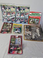 Group shot showing all items: Devil Rays card sheets, Baseball’s All-Time Greats set, Starting Lineup figures, Baseline game, NASCAR die-cast