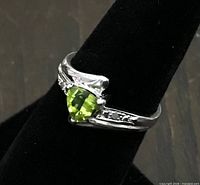 Side view showing triangular green stone, white gold band and accents