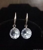 Front view of sterling silver drop earrings with clear round stones