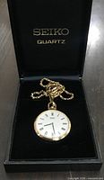 Front view of Seiko Quartz pocket watch in branded box showing dial, chain, and presentation case