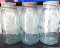 Three matching aqua Crown canning jars with lids shown side by side