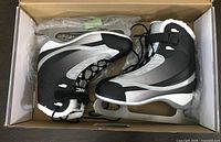 Pair of women’s ice skates in box, showing design and condition