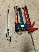Overall view of three caulking guns and one air blow gun attachment