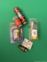 Overview of all hose fittings including packaged Simoniz coupler, packaged 1/4-inch kit, two plastic adapters, loose brass coupler