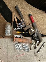 Overview of assorted hand tools, hardware, car jack