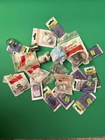 Full lot of assorted packaged plumbing parts on green background