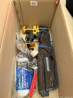 Top view showing DeWalt drill, battery, charger, Mastercraft tool roll and packaged gloves