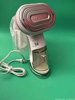 Front view of Conair handheld garment steamer showing steam plate and cord