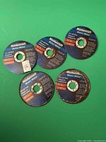 Five Mastercraft cut-off disks on green background