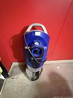 Front view of blue Michelin portable air compressor showing gauge, logo, and damage