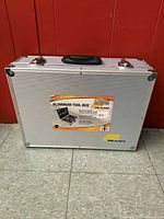 Front view of Plano aluminum tool box with label attached