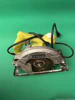 Front view showing Ryobi branding, blade, cord, and base