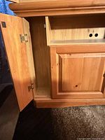 Cabinet side door open showing storage area and hinges