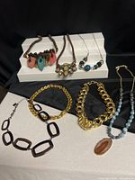 All six necklaces displayed on black and white backgrounds