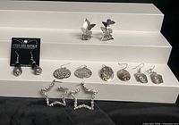 All seven earring pairs displayed on stepped stand