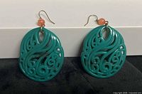 Front view of both earrings showing carved design and overall style