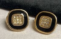 Front view showing black enamel border and rhinestone centre of both earrings