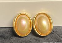 Front view showing oval faux pearls and gold-tone setting