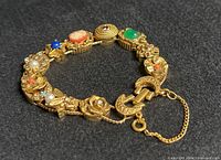 Full bracelet laid flat showing all slide charms and safety chain