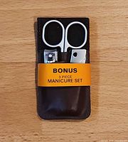 Front view showing scissors, two clippers and leather pouch with retail band