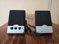 Front view of both speakers showing controls and wires