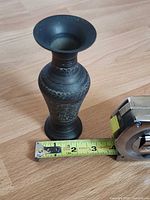 full view of brass vase beside tape measure showing scale
