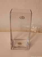 Full view of clear rectangular glass vase with HJK side sticker visible
