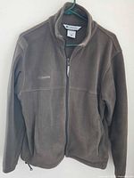 Front view of brown Columbia fleece jacket on hanger