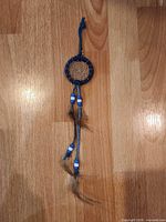 Full view of dreamcatcher keychain showing overall design and dangling feathers