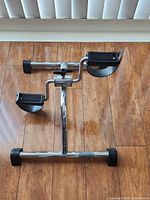 Full view of chrome pedal exerciser on floor