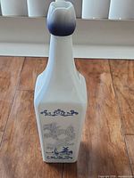 Front view showing square body, blue Delft scene and tulip stopper