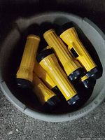 View of multiple yellow flashlights inside grey bucket