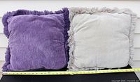 Front view of both pillows showing colors, size reference tape