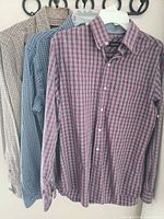 Three plaid shirts hanging showing overall condition and colors